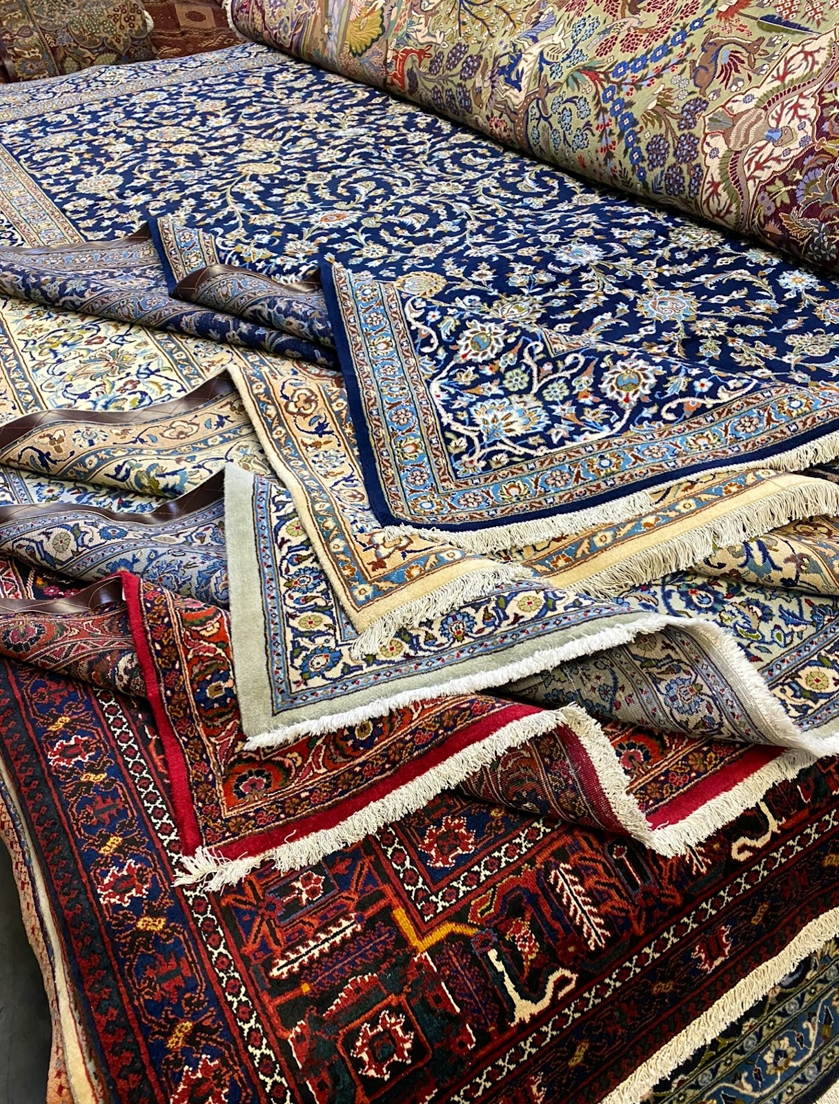 A visually stunning Persian rug displayed on a floor. Its intricate designs and vibrant colors reflect the artistry and storytelling embedded in these timeless pieces. The rug evokes a sense of enchantment and cultural heritage, showcasing the craftsmanship that brings it to life. This captivating rug is a testament to the rich tradition of Persian rug weaving, offered by RugMaster.