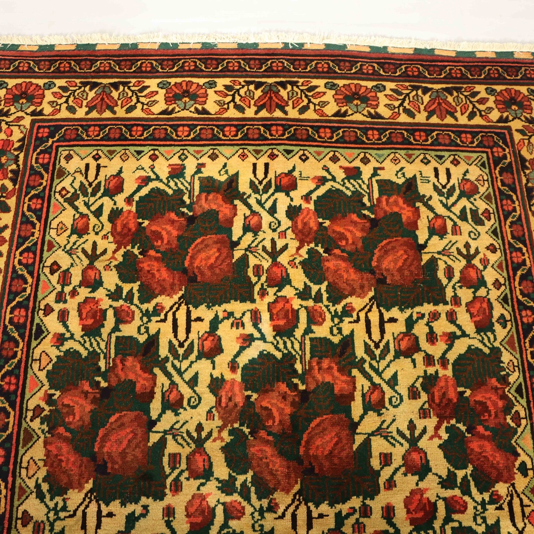 A photo of a vintage Persian rug with a classic design and a faded color palette. The rug has a unique patina and character that adds a touch of history and elegance to any home decor.
