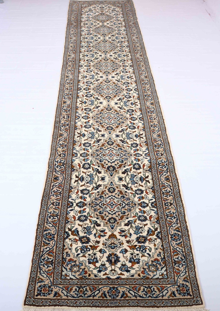 A hallway with a Persian runner rug running down the center. The rug features a traditional Persian design in bold colors and adds elegance and style to the hallway decor while also protecting the floor.