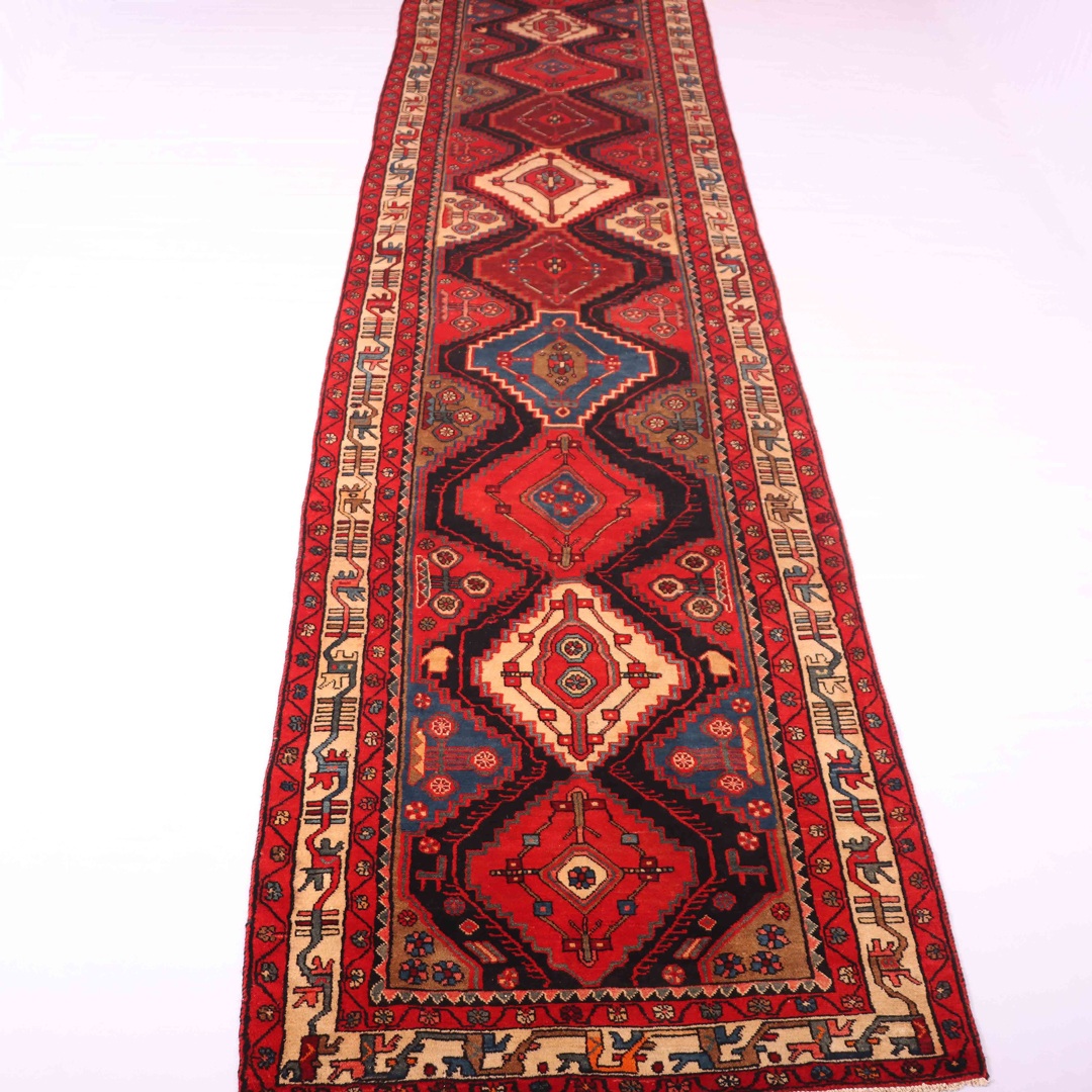 Long, colorful hallway runner stretching down a hardwood hallway, with a variety of patterns and designs on display. The runner is provided by RugMaster, a seller of high-quality and affordable rugs. This image accompanies an article discussing the benefits of using hallway runners to add warmth and color to your home's hallways. Hallway runners come in a variety of styles and lengths, and RugMaster offers a wide selection of runners to fit your style and budget.