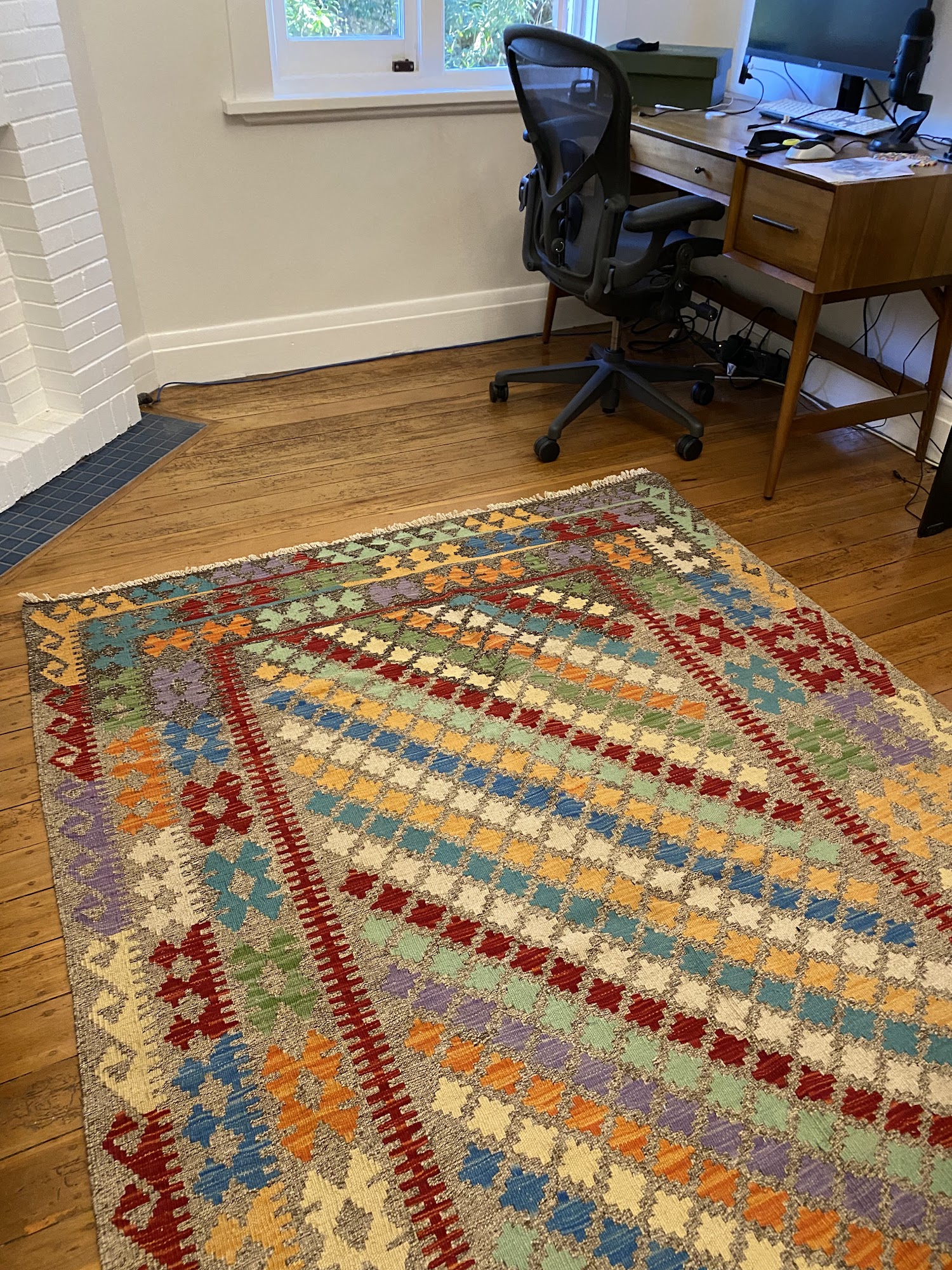 A close-up view of a handwoven Oriental rug, showcasing intricate patterns and vibrant colors that depict rich cultural heritage and timeless craftsmanship. The rug serves as a testament to artisan dedication and skill, symbolizing an integral component of interior design that anchors and defines living spaces.